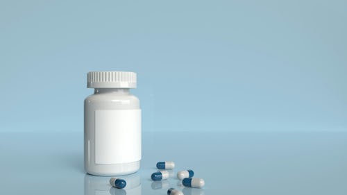 Image showing a bottle of supplement with some capsules poured out on a table
