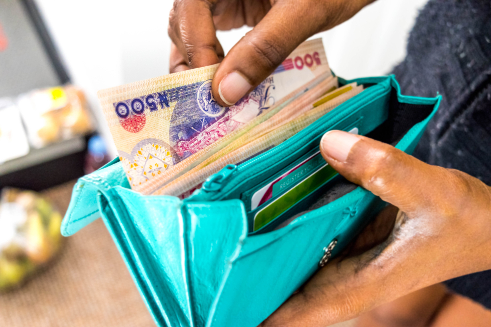 A woman bringing out money from her purse to make an out-of-pocket payment