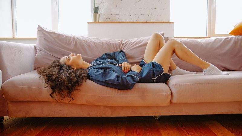 A girl lying on the couch with hands on her belly