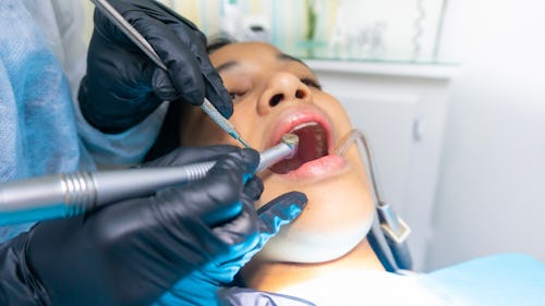 Image of a lady having her teeth checked out by a dentist at a dental clinic