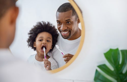 Man brushing teeth with his child