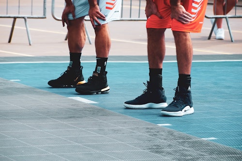 Two men on a running track wearing sneakers shoes