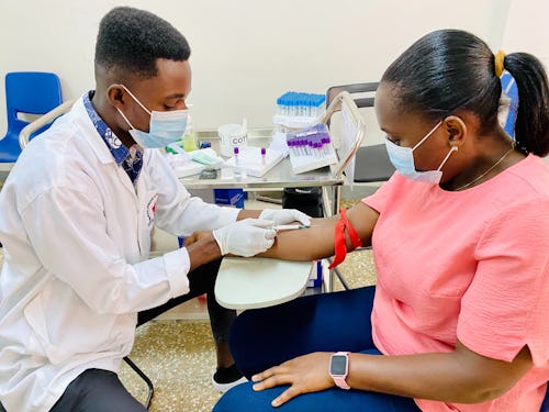 Lab scientist taking a patient's blood sample for a blood typing test