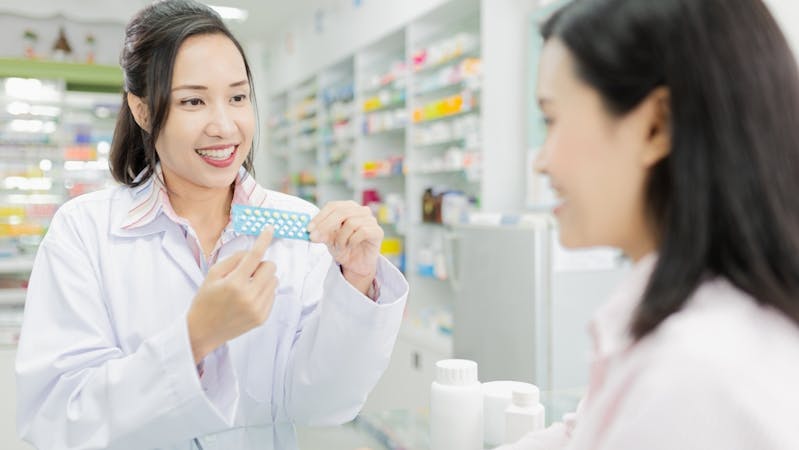 Pharmacist showing a doctor how to use contraceptive