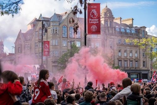 a crowd of people standing around a red smoke bomb