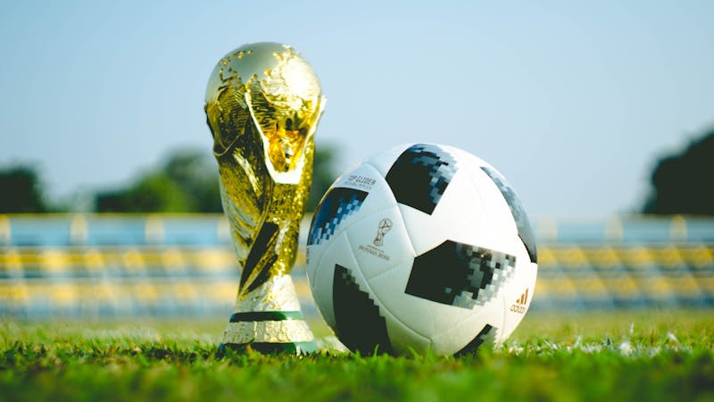 Image of the FIFA World Cup trophy next to a ball