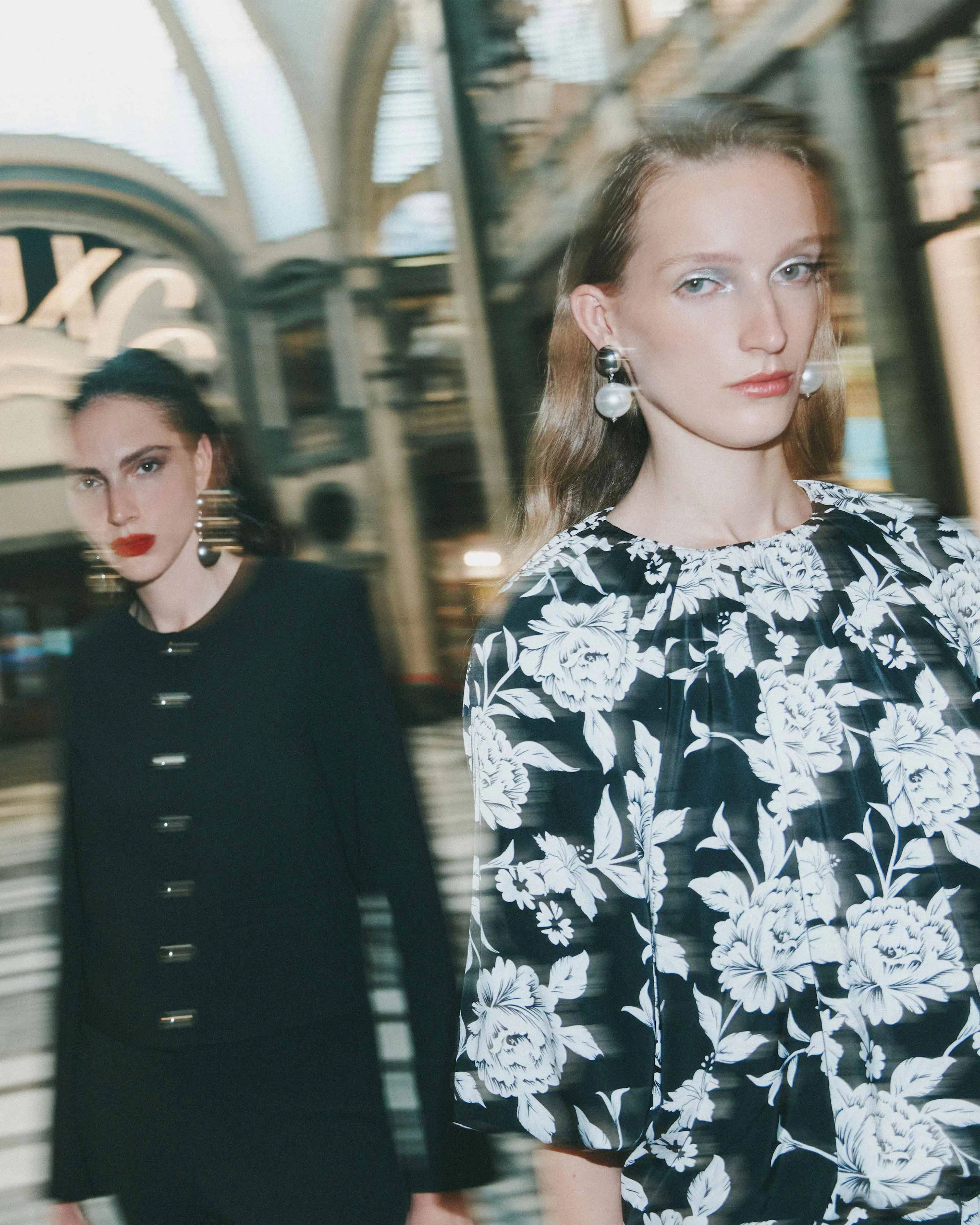 Due ragazze sfocate in una galleria elegante vestite Calliope