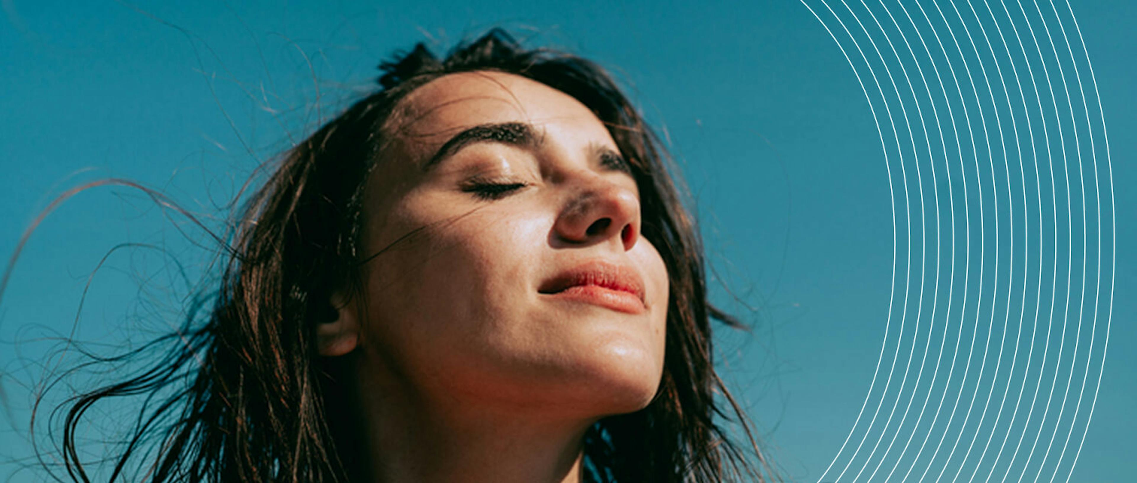 Ritratto di una giovane persona con gli occhi chiusi e il viso rivolto verso l'alto, in un'espressione serena contro un cielo azzurro. La composizione include elementi grafici lineari curvi che completano l'estetica dell'immagine