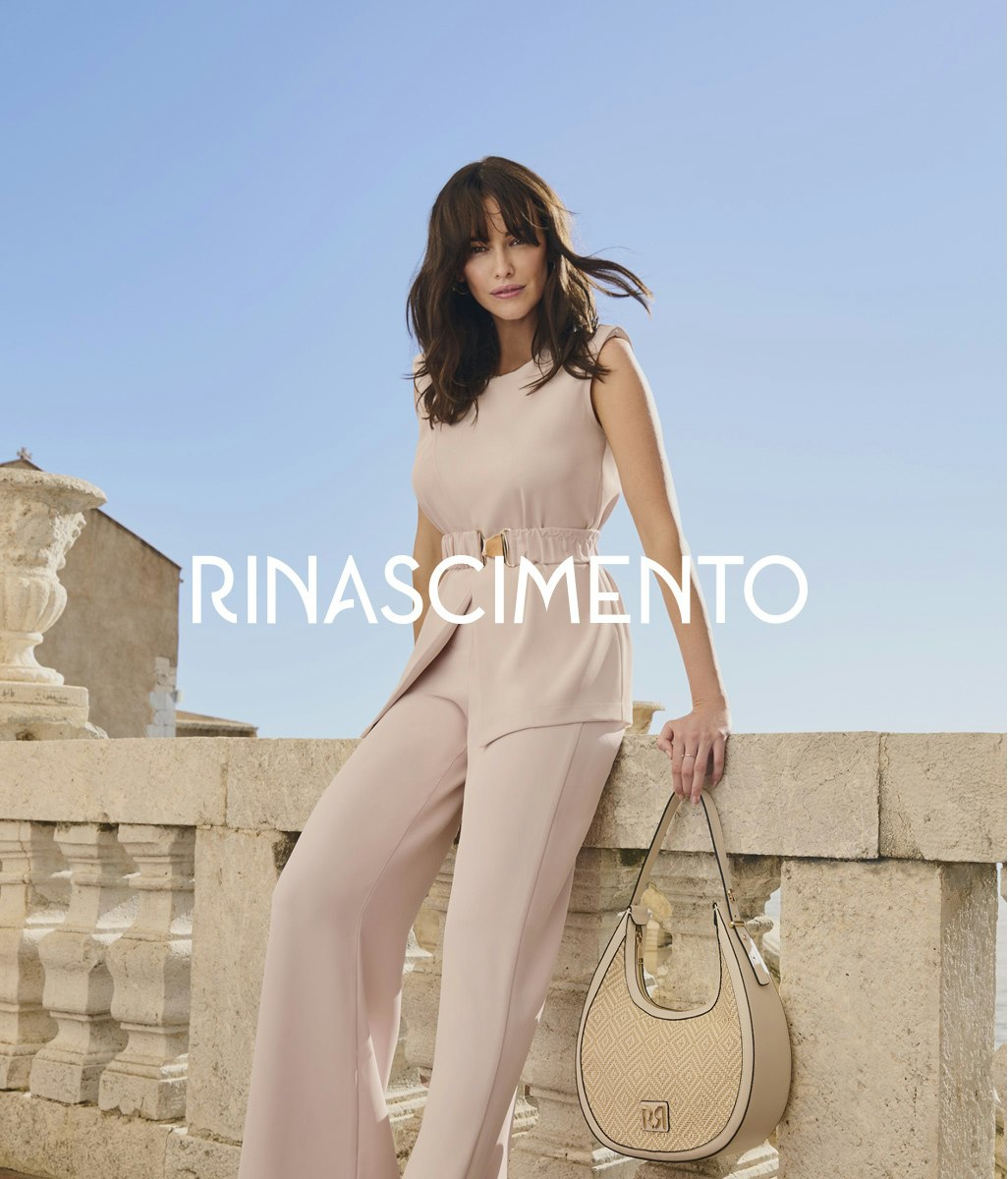 Modella in elegante completo beige composto da top senza maniche e pantaloni a gamba larga con cintura, che tiene una borsa beige, in posa contro elementi architettonici in pietra. Il nome Rinascimento appare in lettere bianche
