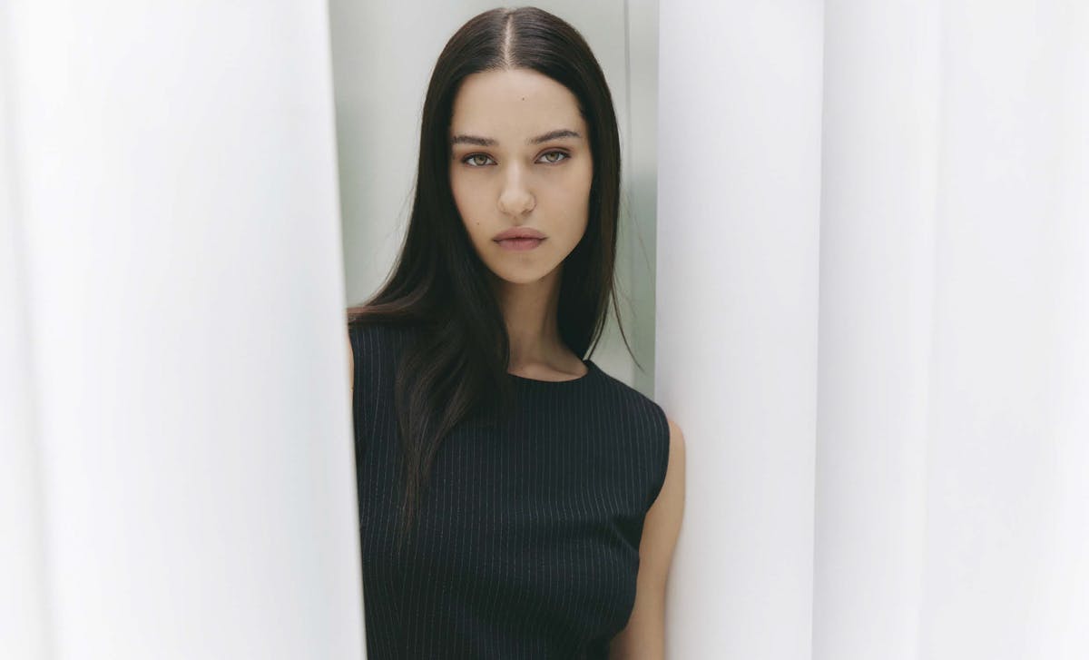 Una ragazza vestita di nero guarda dritta l'obiettivo della macchina fotografica