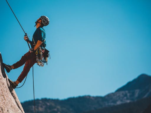 A man climbing a vertical rock face in Catalonia