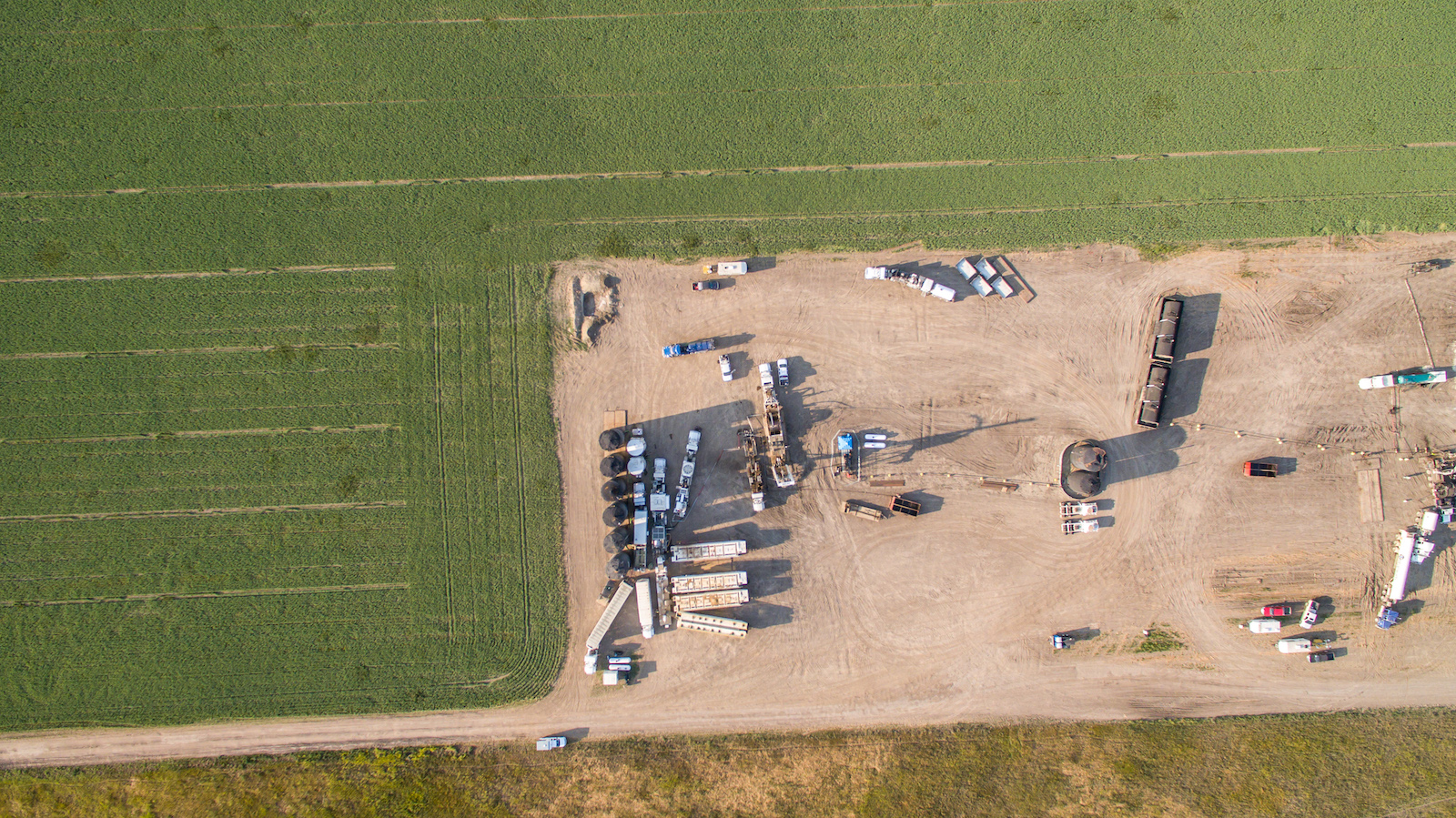 An aerial view of an oil rig and various trucks.