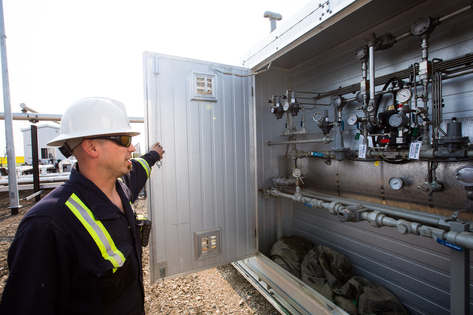 An oil worker taking a look at a panel full of complex dials.