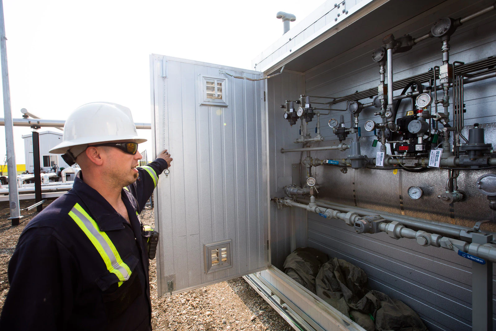 An oil worker taking a look at a panel full of complex dials.