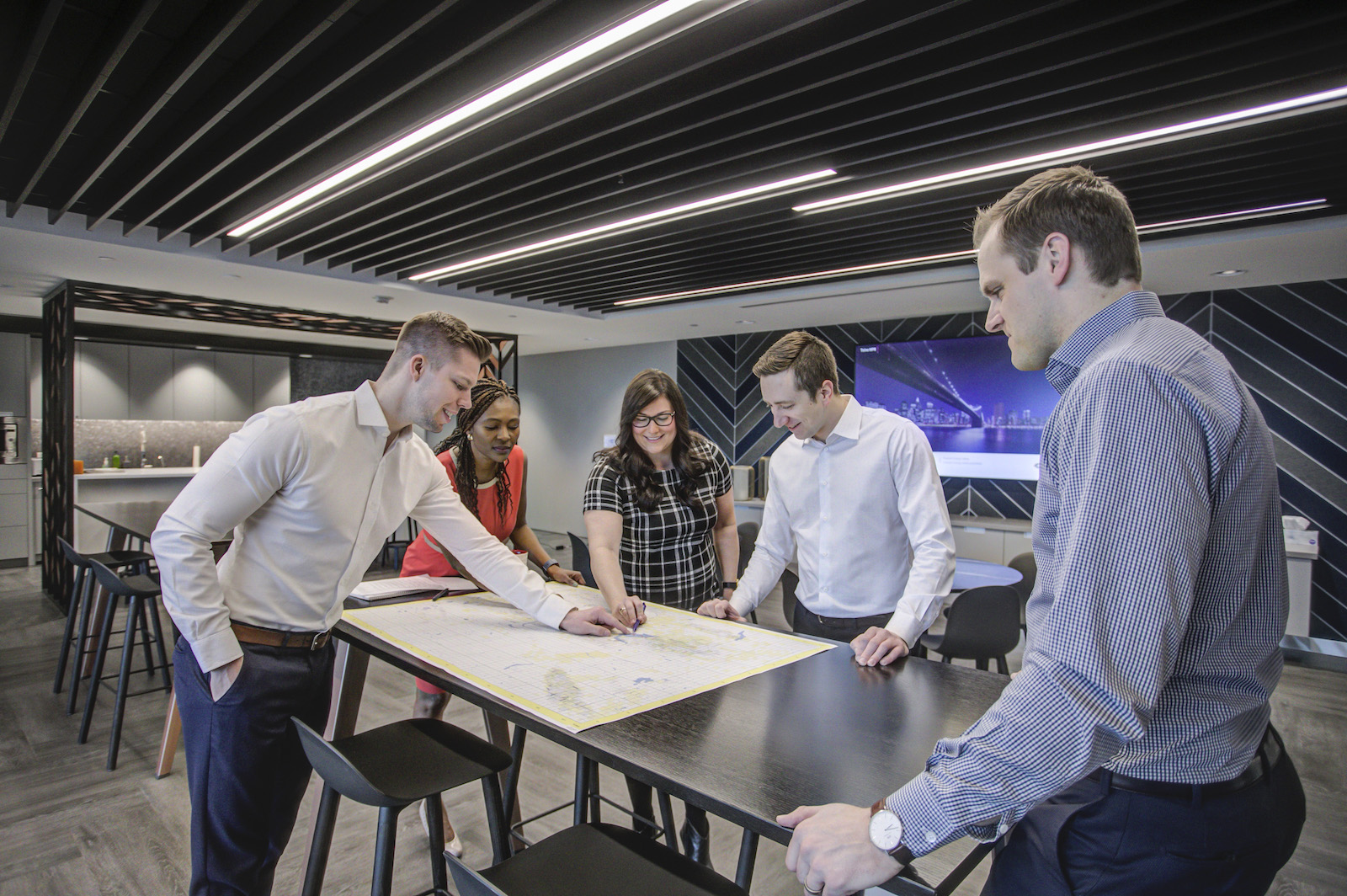 Workers discussing blueprints at a desk.