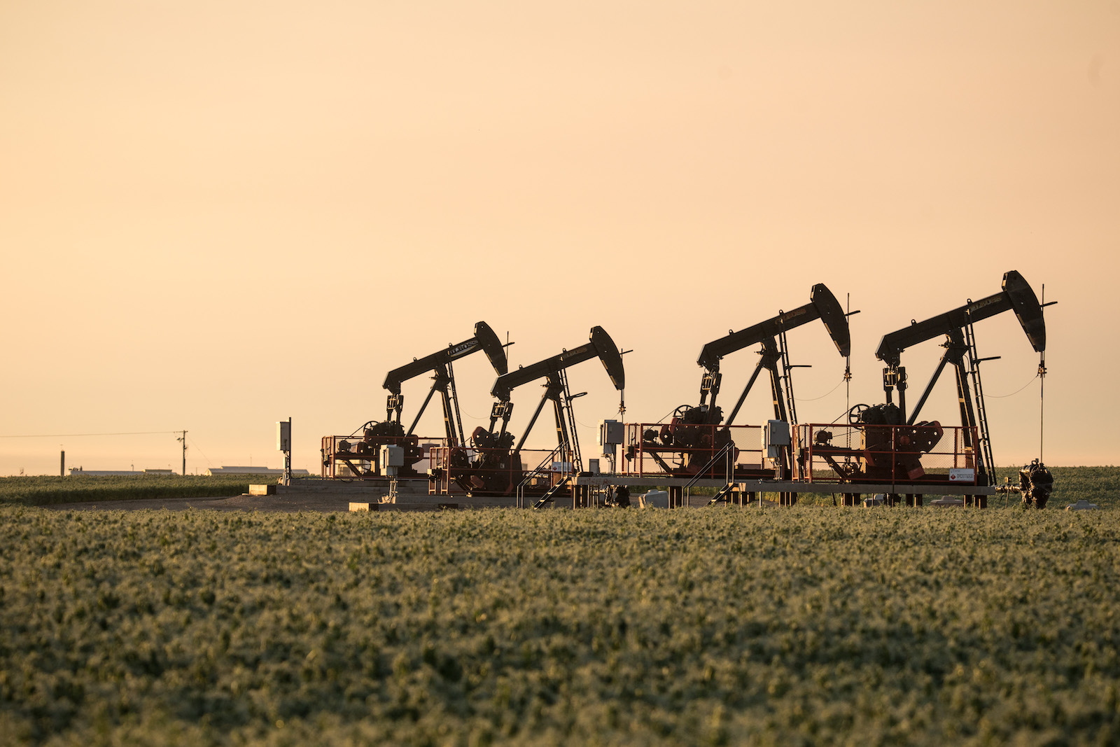 Oil machinery lit by hazy evening light.