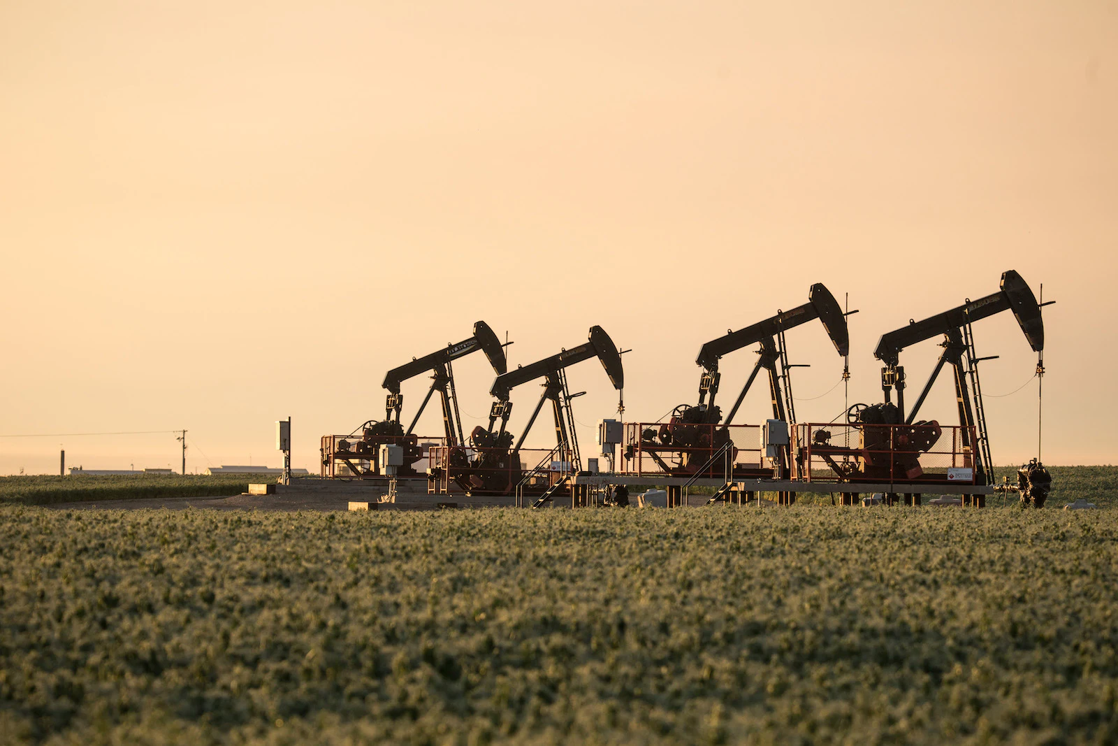 Oil machinery lit by hazy evening light.