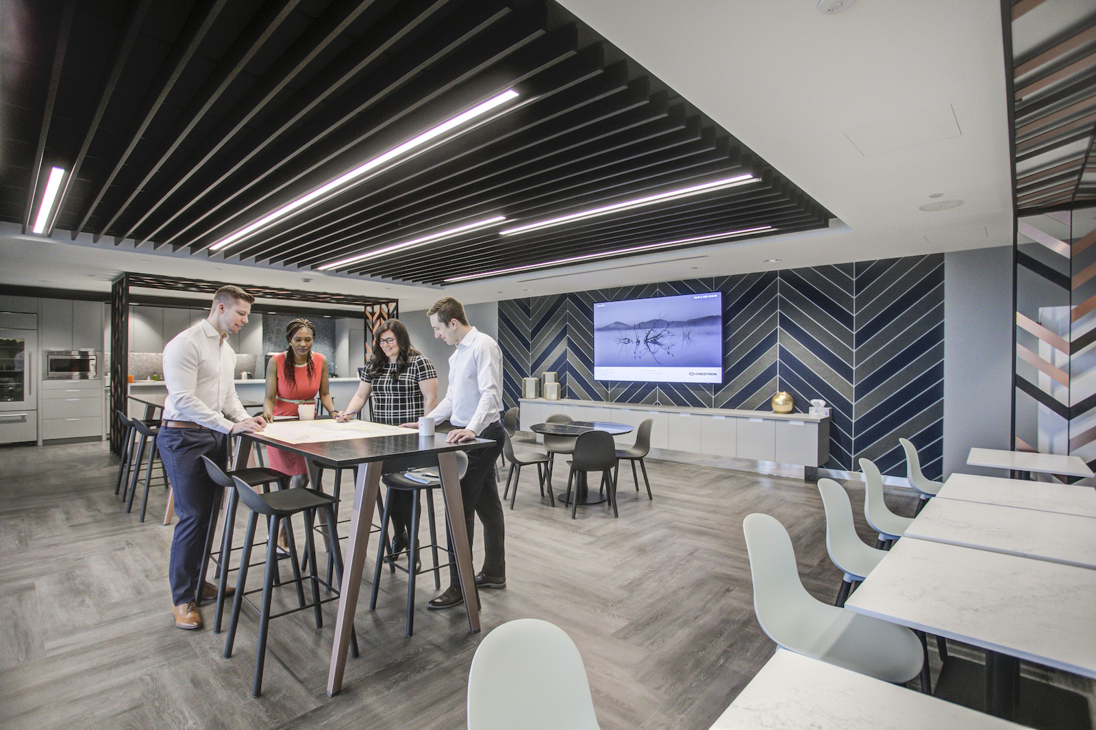 Office interior, with young office workers discussing a blueprint around a table.