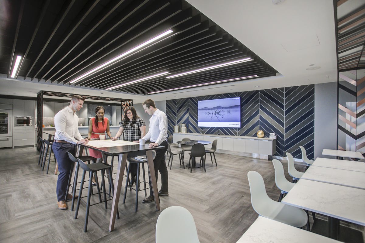 Office interior, with young office workers discussing a blueprint around a table.