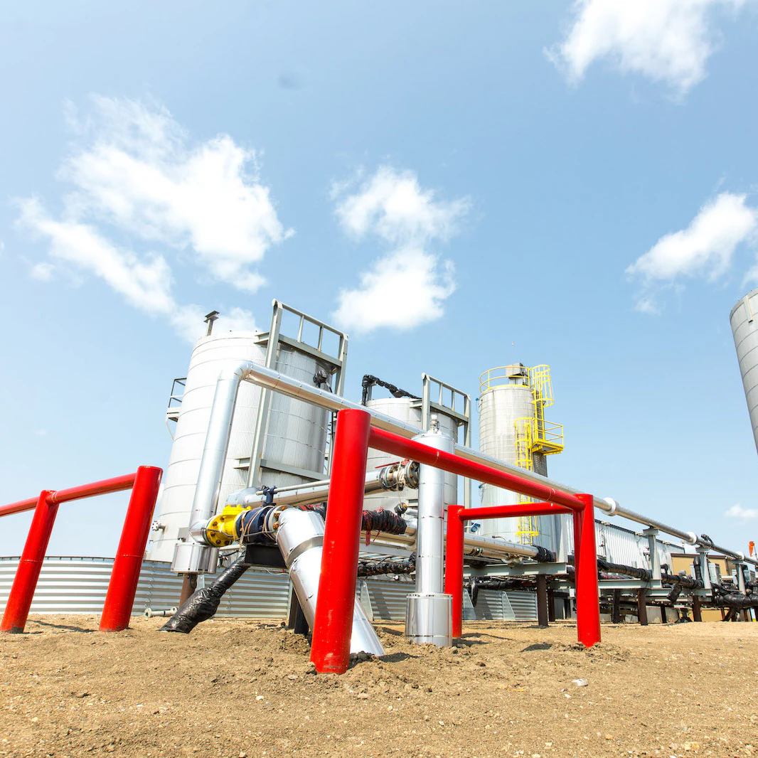 Large oil towers with red railings in the foreground.