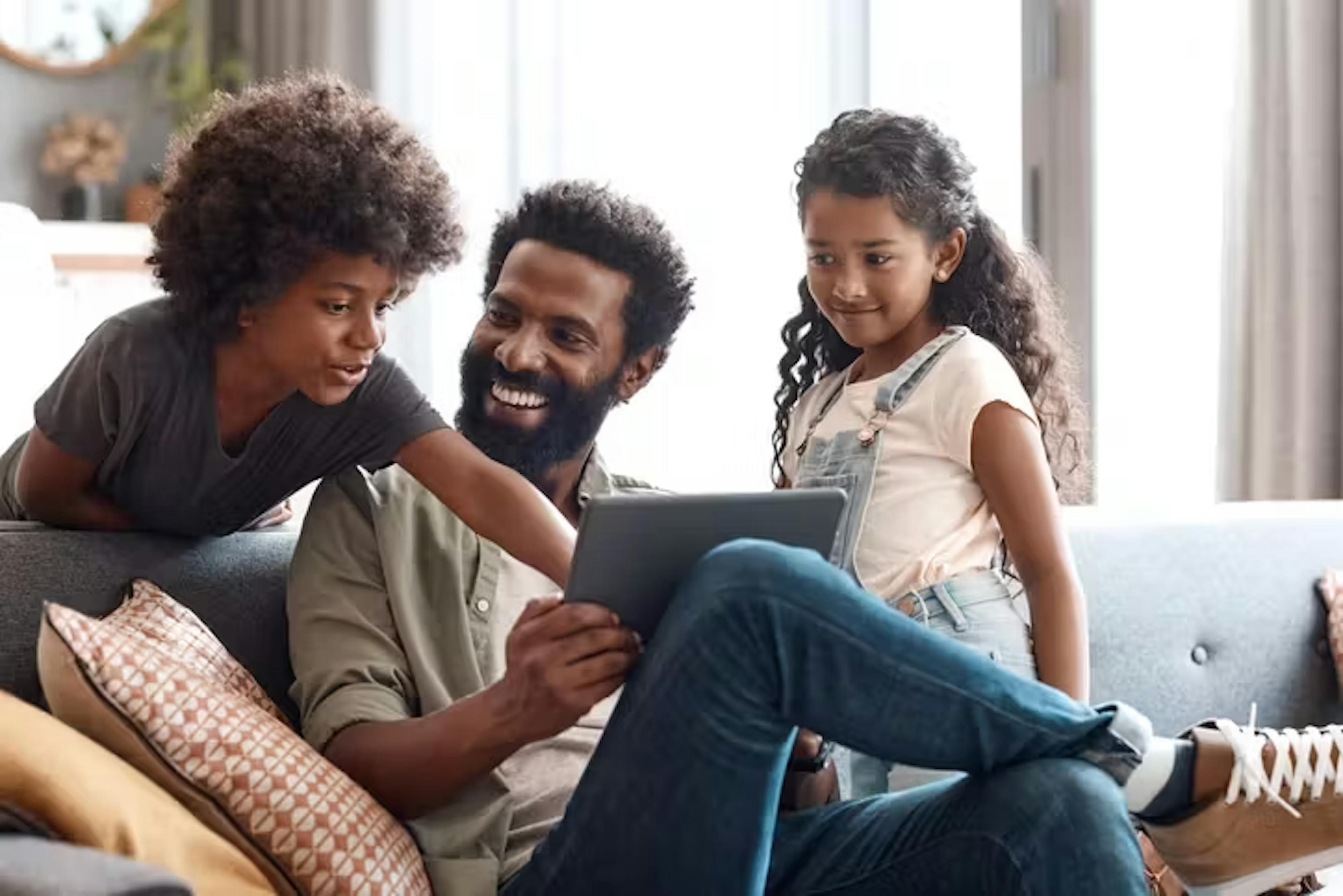 familia sentada no sofa mexendo em um tablet aproveitando os planos de combo da claro