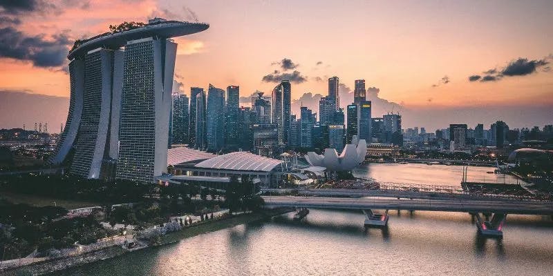 Singapore skyline at sunset featuring iconic architecture.
