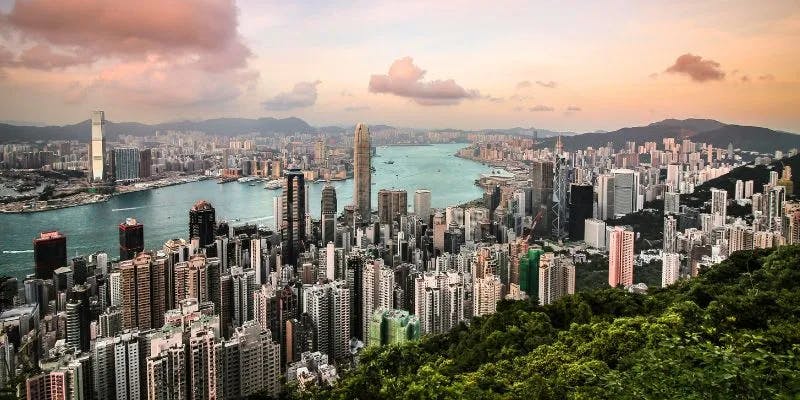 A panoramic view from a high vantage point over Hong Kong at sunset.