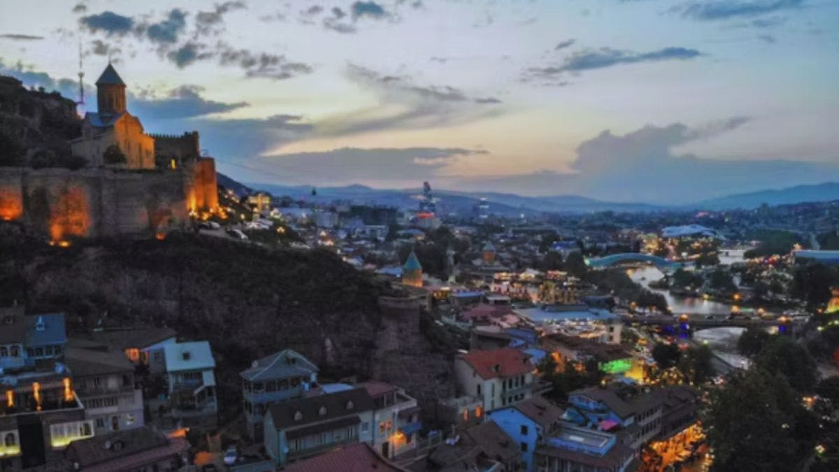 Cityscape with illuminated castle at dusk.