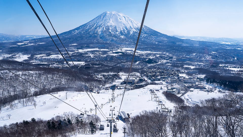 Snowy mountain with ski lifts.