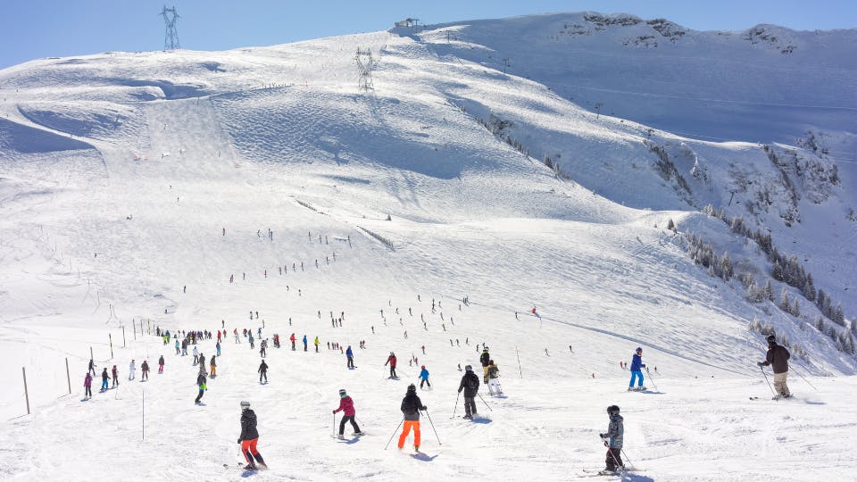 Skiers on snowy mountain slopes.