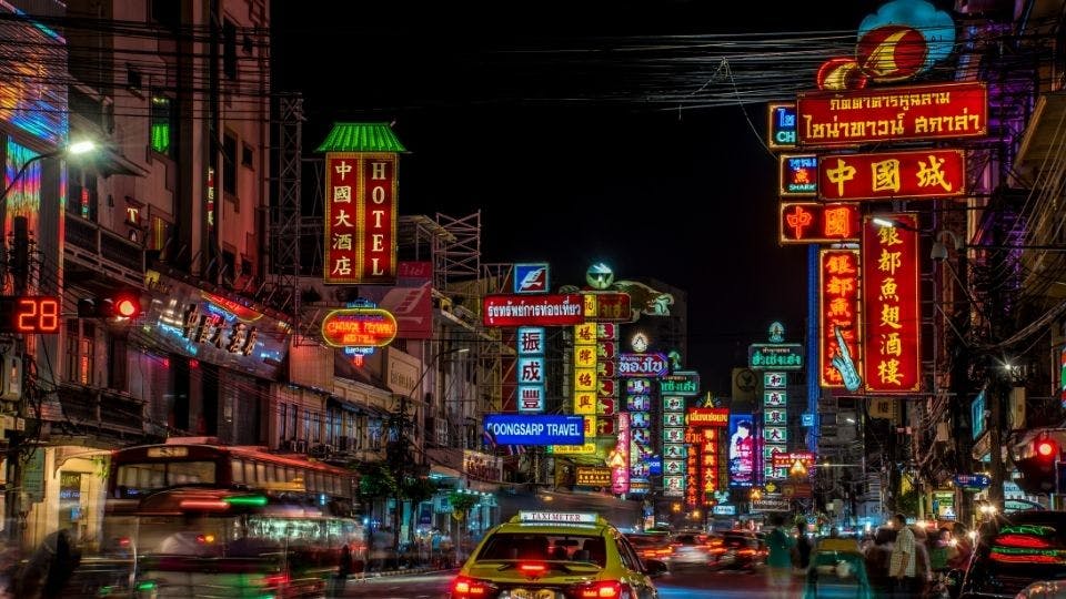 Bustling city street with neon signs.