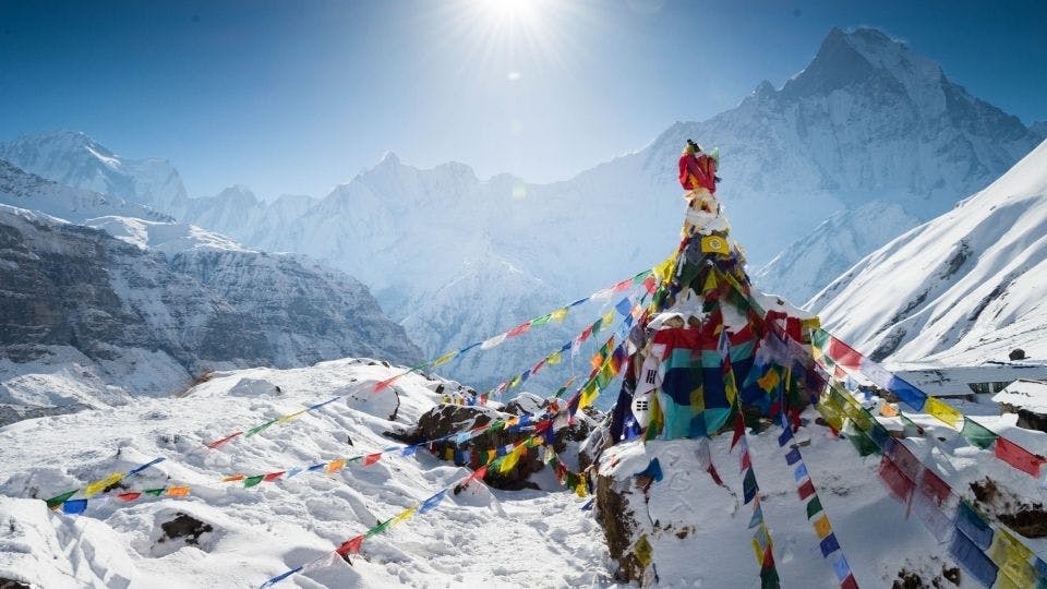 Snowy mountain landscape with prayer flags.