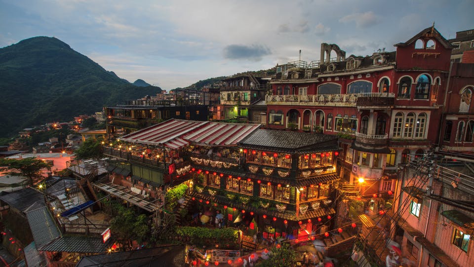 Hilltop village with lit cafes.