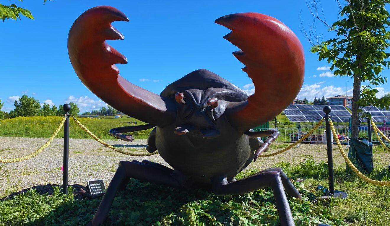 A giant fake monster insect with big red pincers at TELUS Spark
