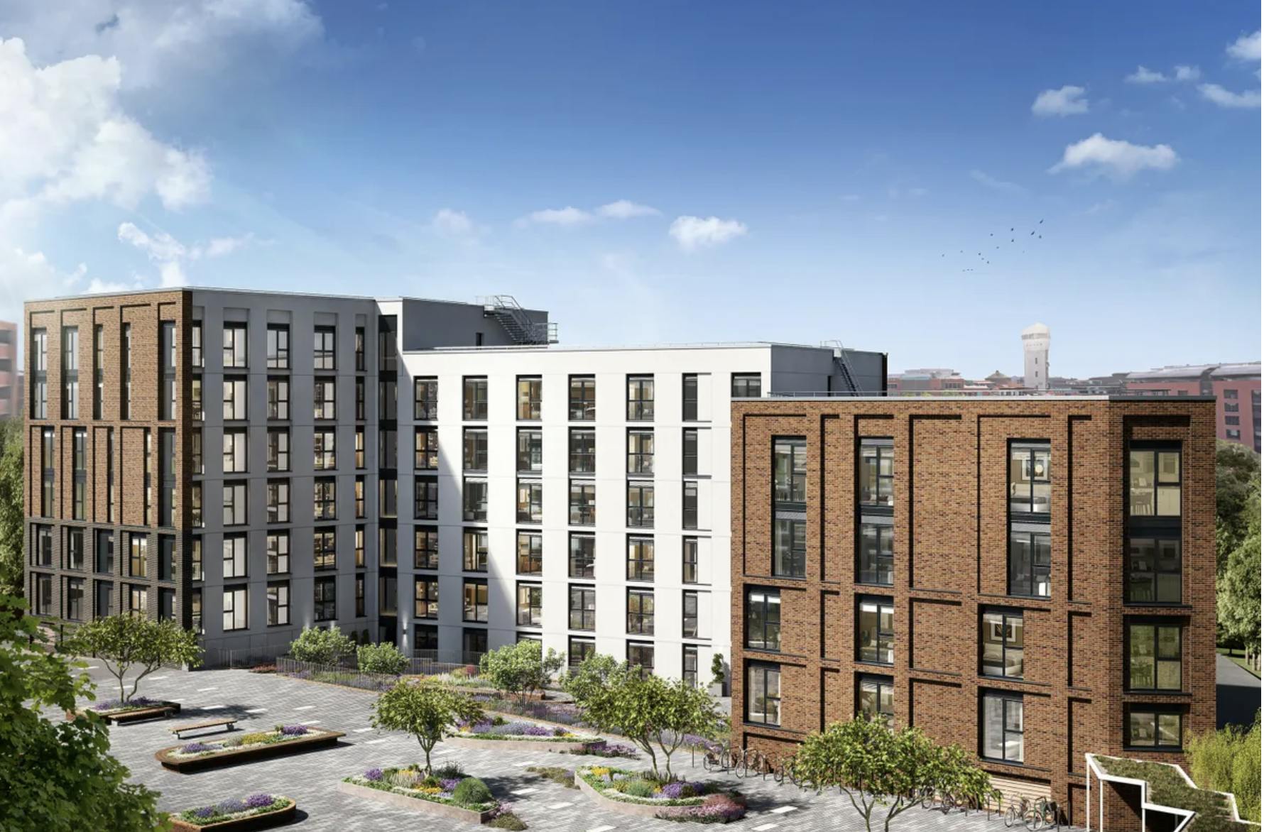 Three blocks of cladded white and brick flats against a blue sky.