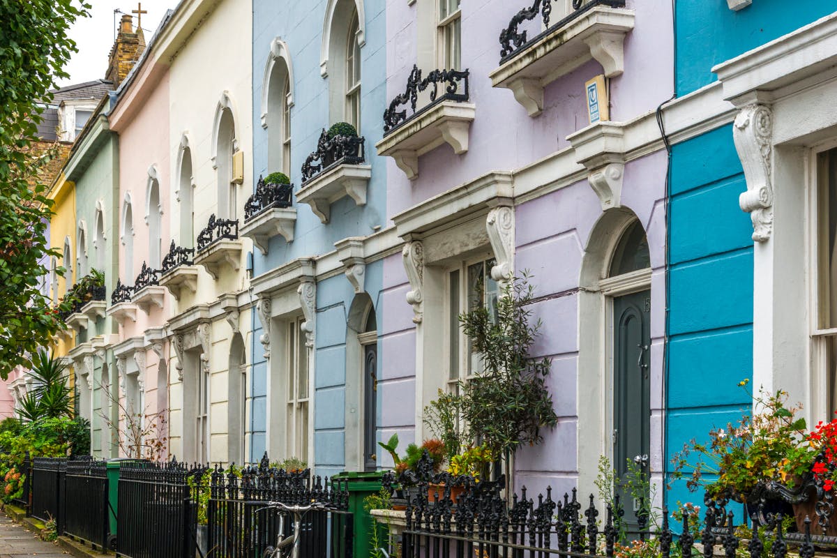 Row of brightly coloured Georgian town houses with iron fences.
