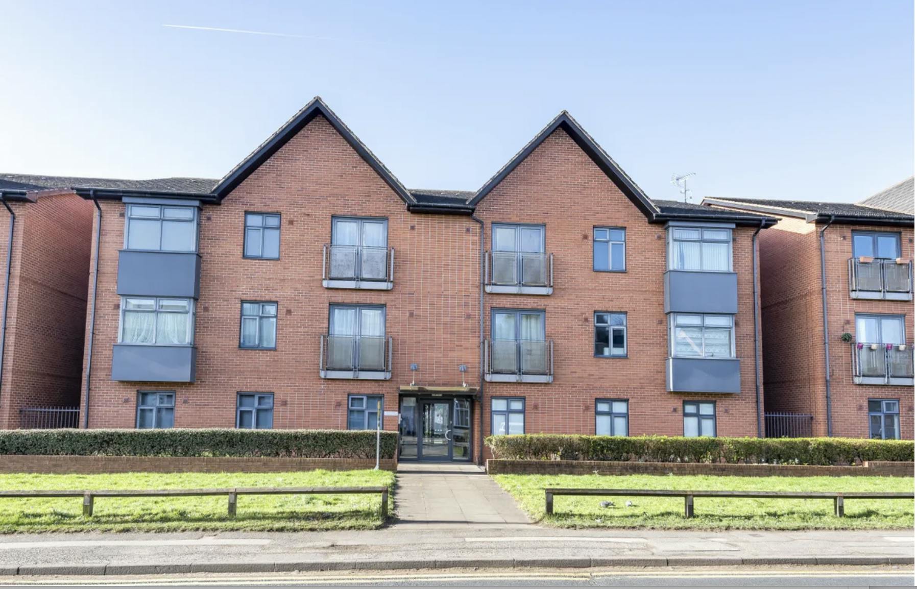 Large block of brick flats with a path leading through the centre of the image.