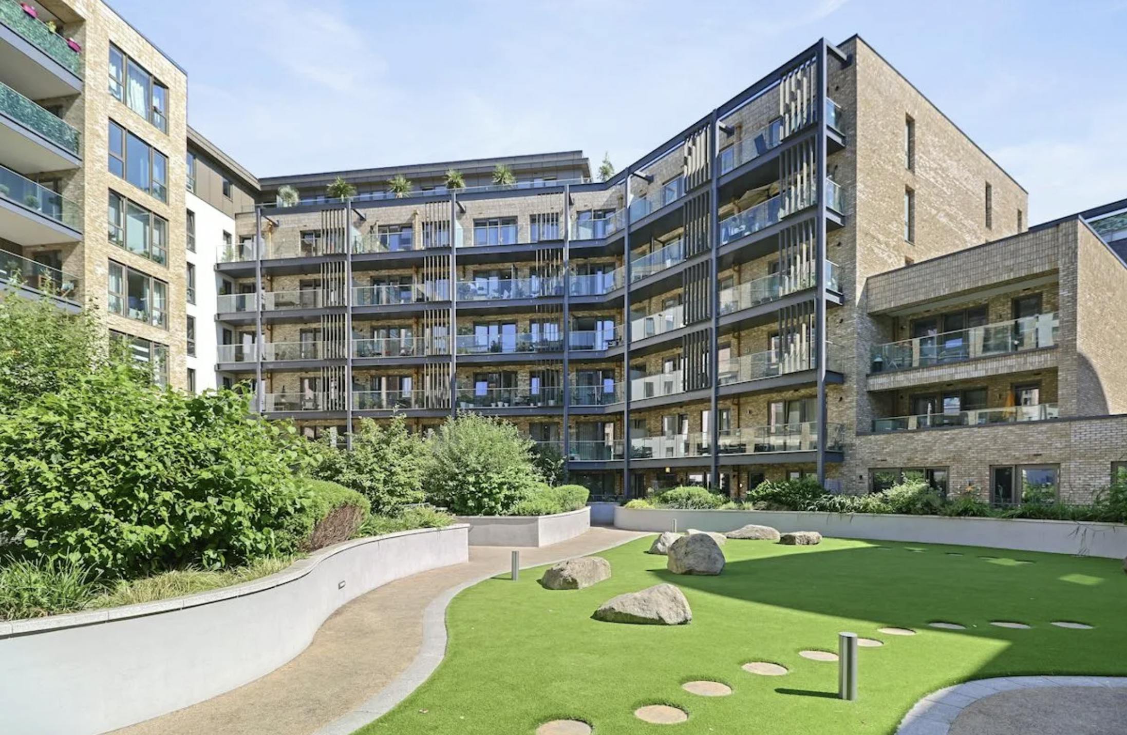 Large block of flats with grass in the foreground.