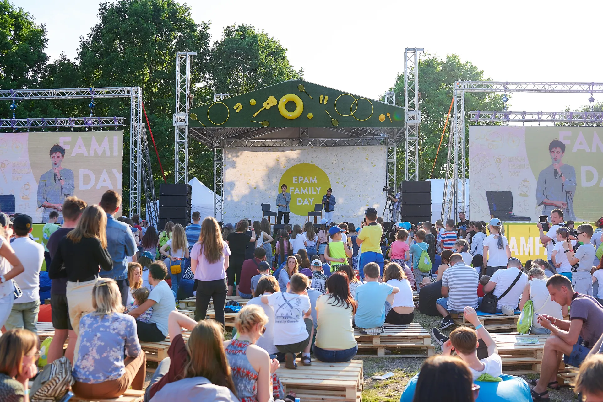 Główna scena EPAM Family Day z ekranami LED i rodzinami na siedziskach z palet w parku