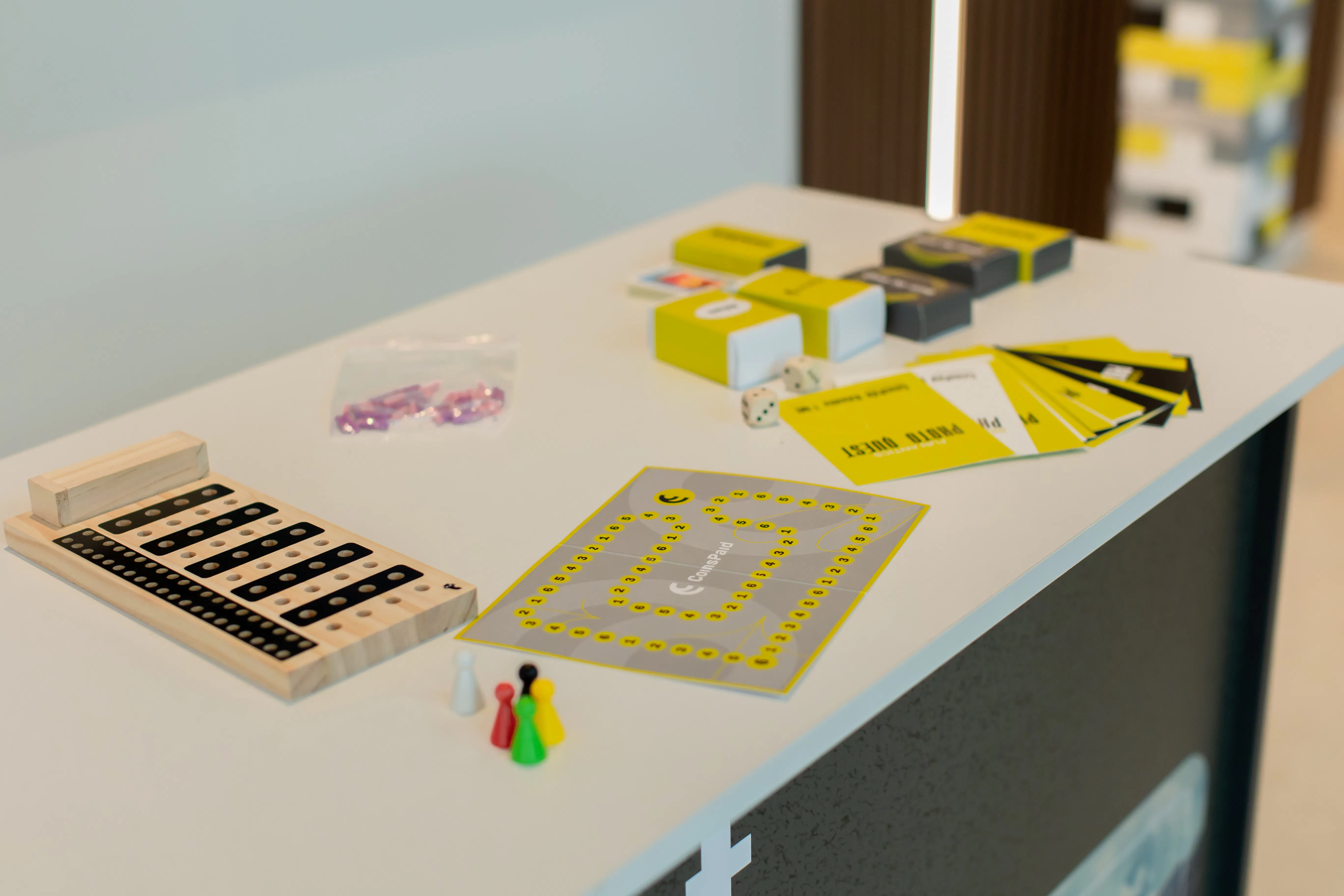CoinsPaid-branded Photo Quest board game, cards and dice laid out on the quest desk