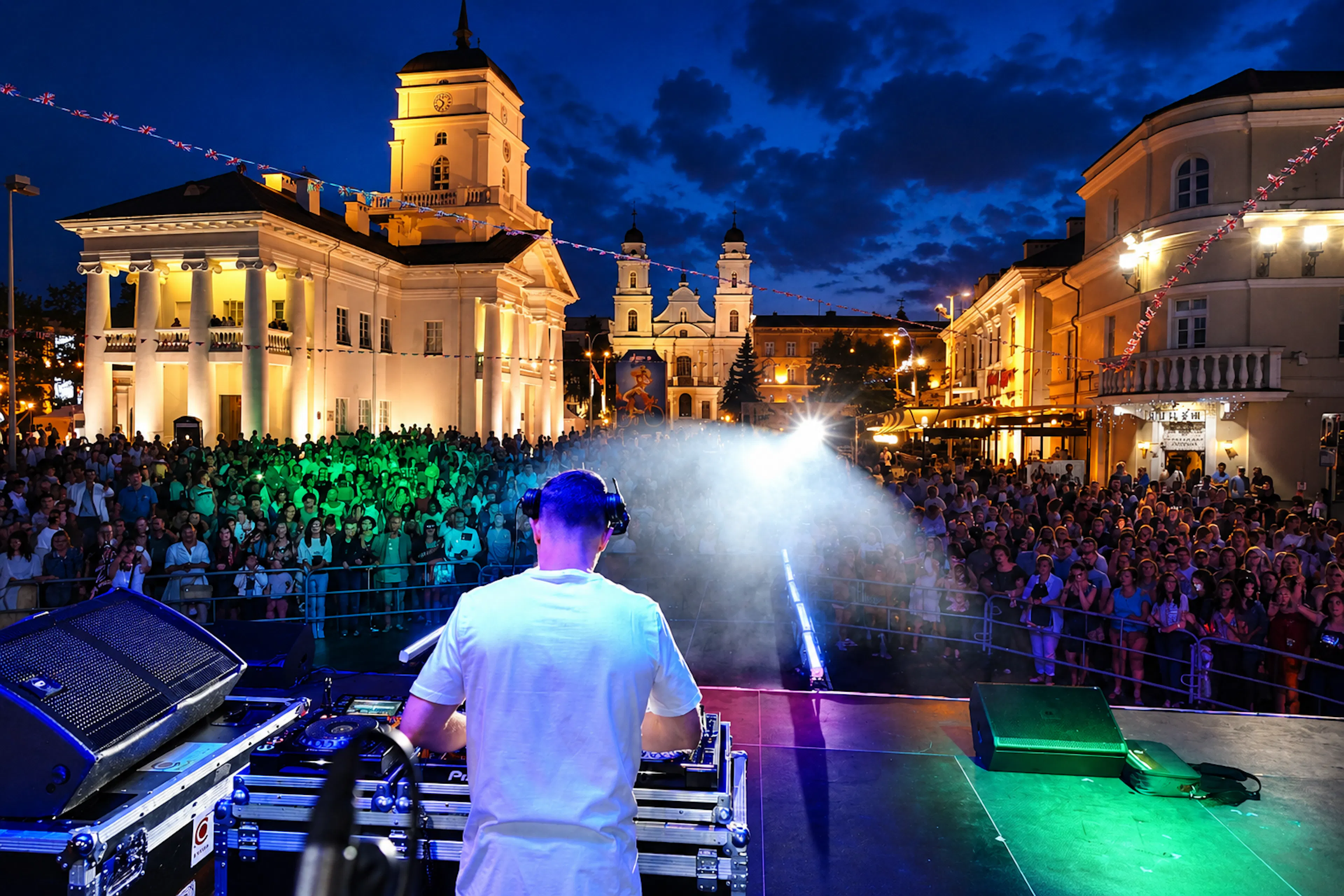 Nocny koncert na Festiwalu Brytyjskim: DJ na scenie przed tłumem na historycznym rynku udekorowanym flagami brytyjskimi