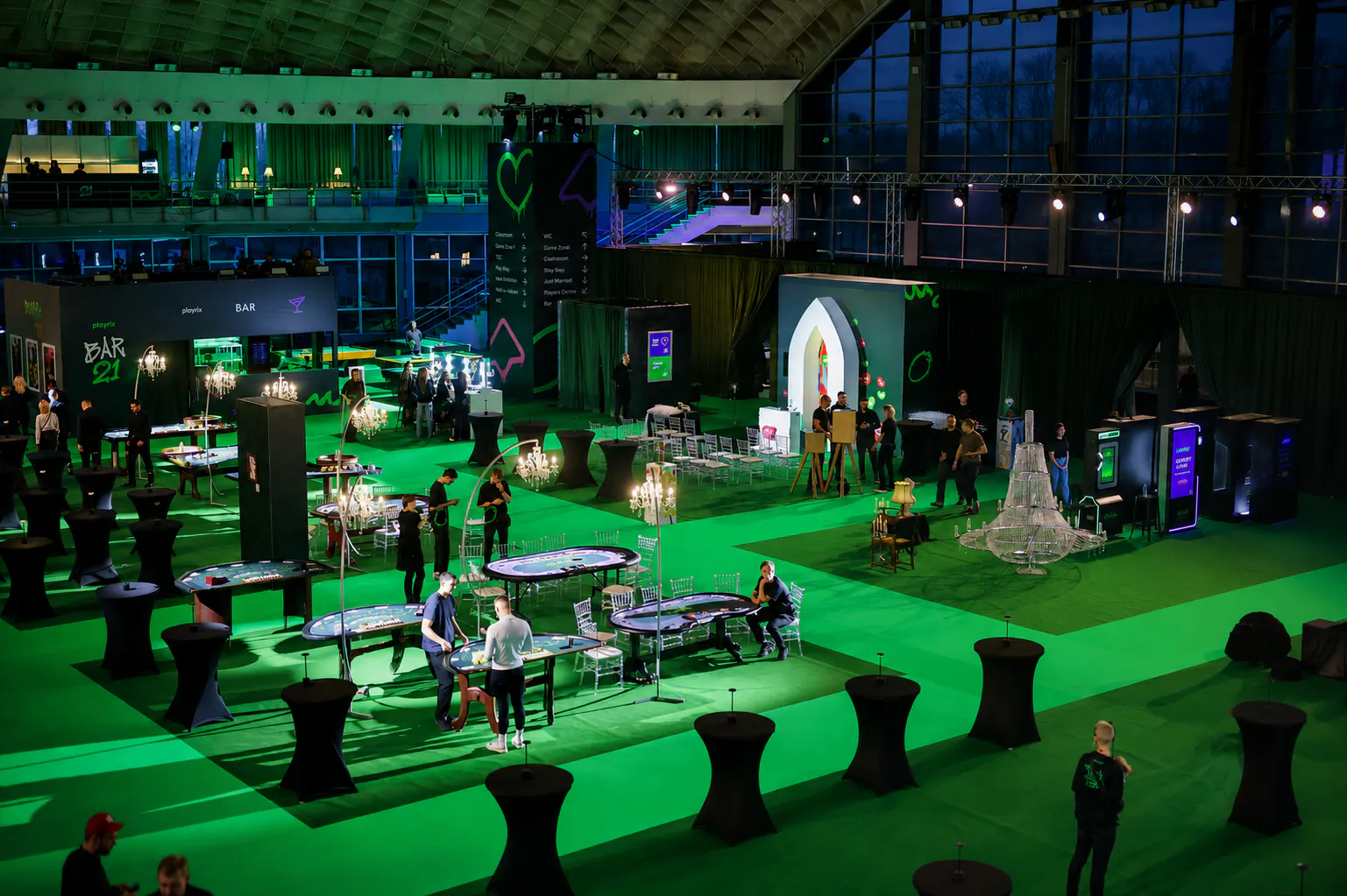 BAR 21 casino zone with gaming tables, chandeliers and high tables on green carpet at the Playrix event