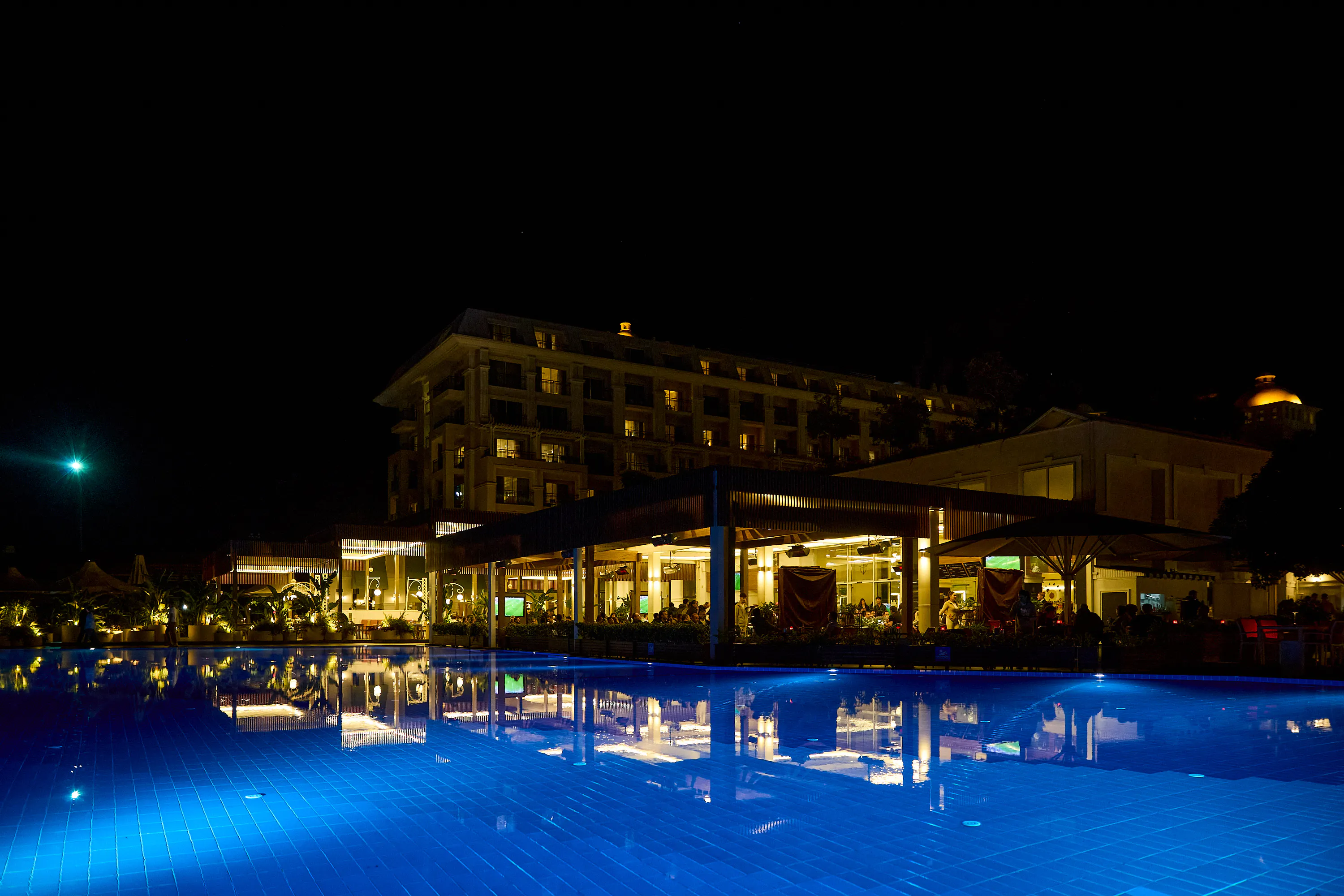 Resort pool lit blue at night during the CoinsPaid event in Turkey