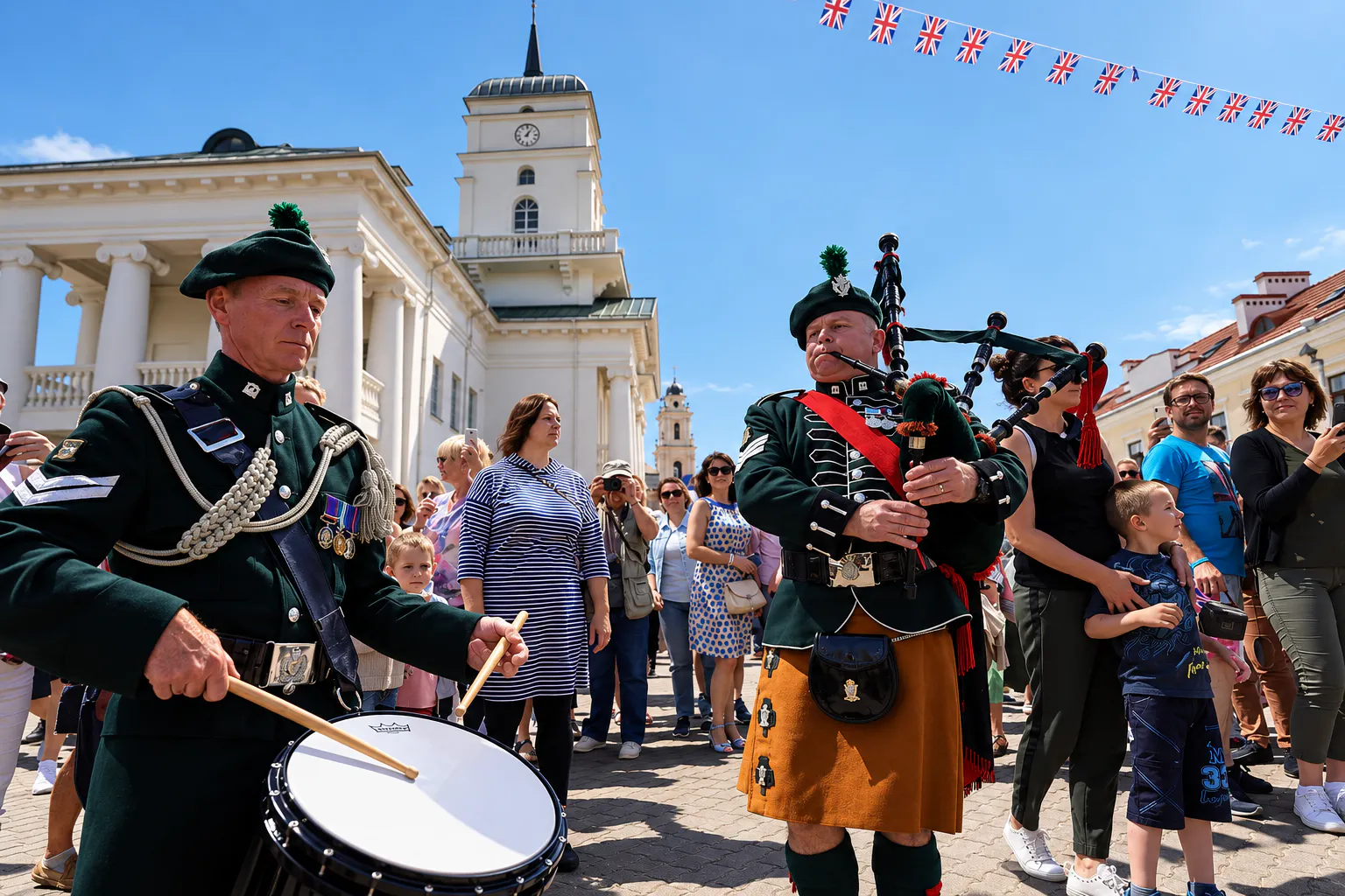 Drummer and bagpiper in Scottish regimental uniforms performing among festival crowds