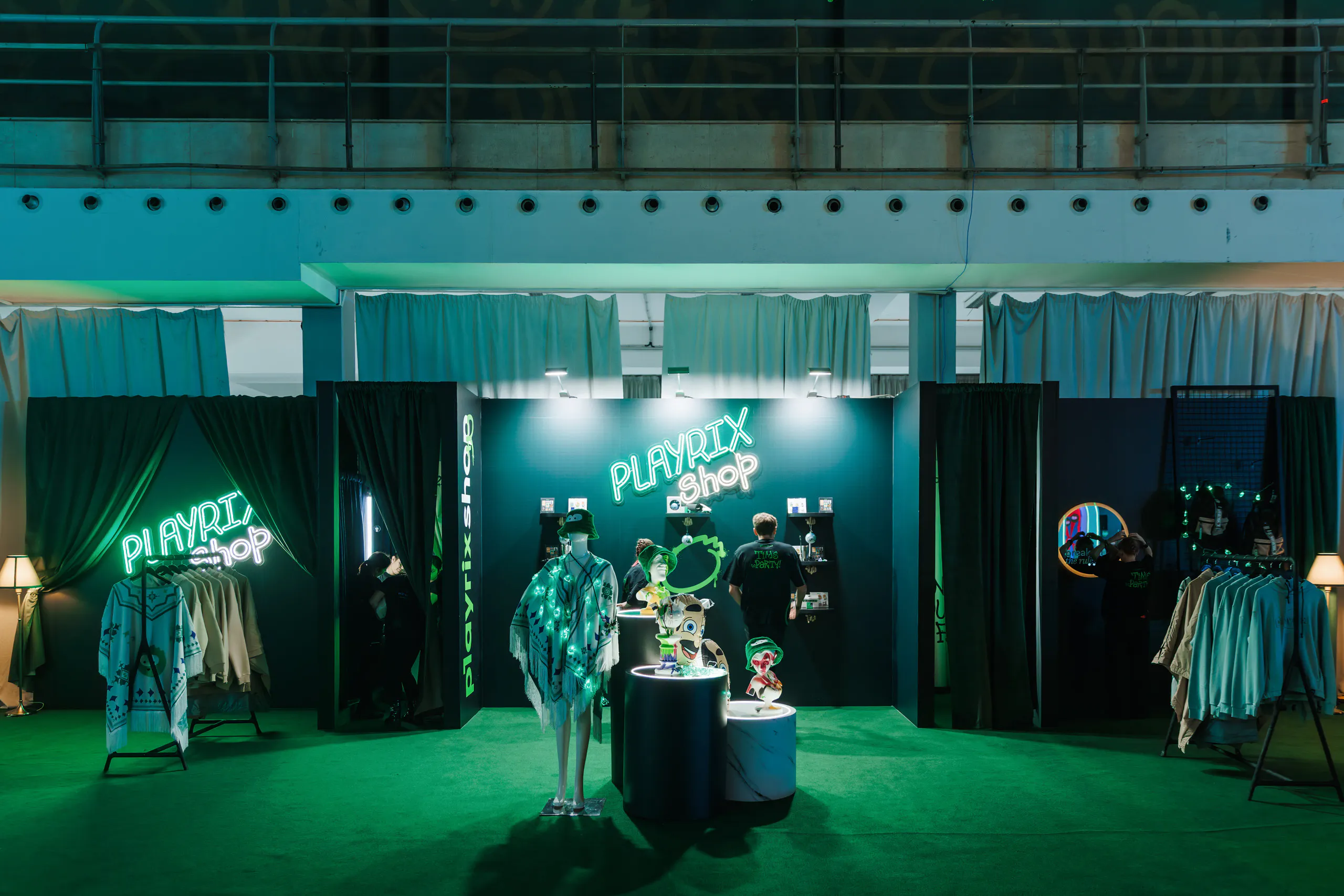 Playrix Shop pop-up with neon signs, branded apparel racks, a mannequin and character figurines