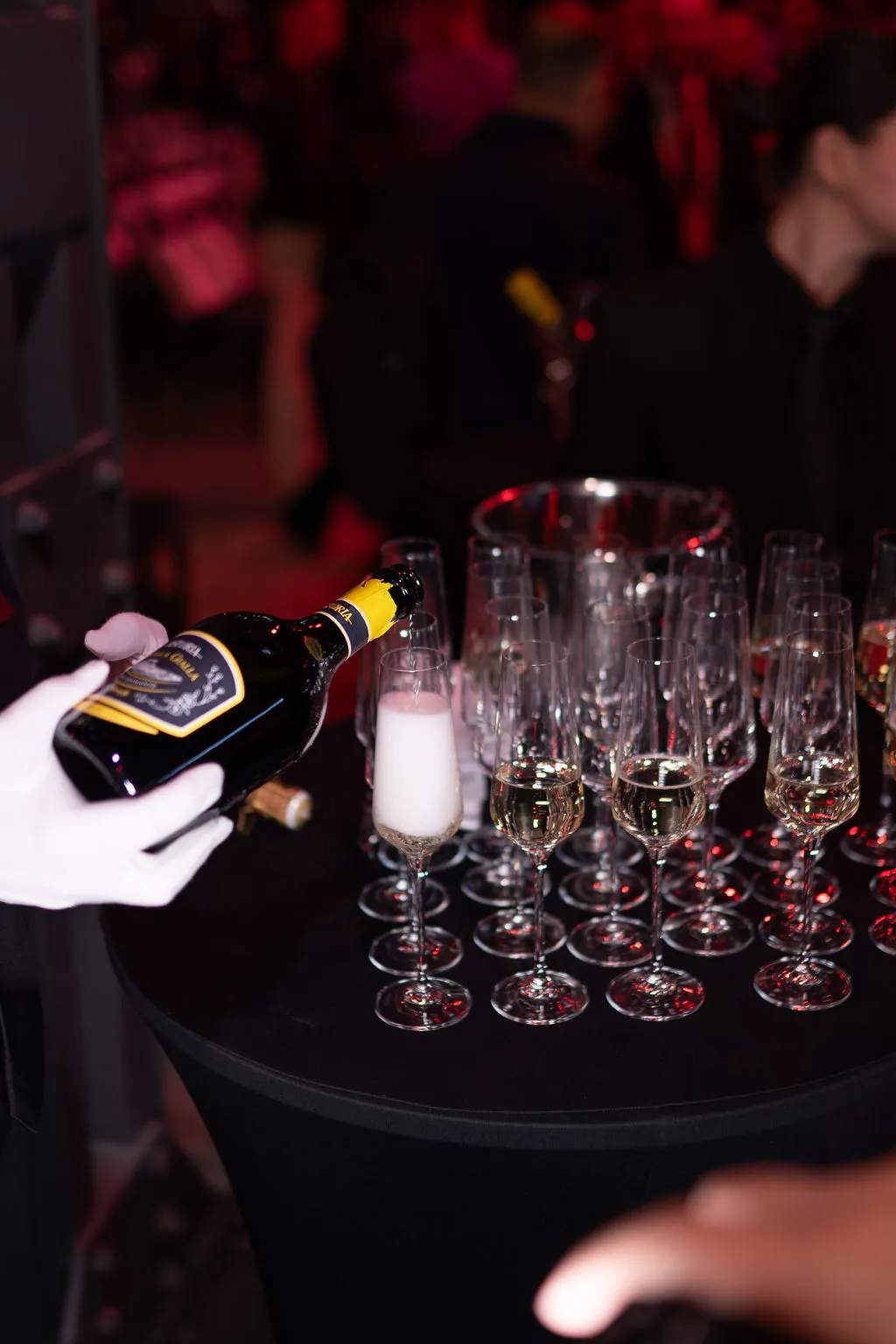 Waiter in white gloves pouring sparkling wine into flutes at the Boost Forum Berlin reception