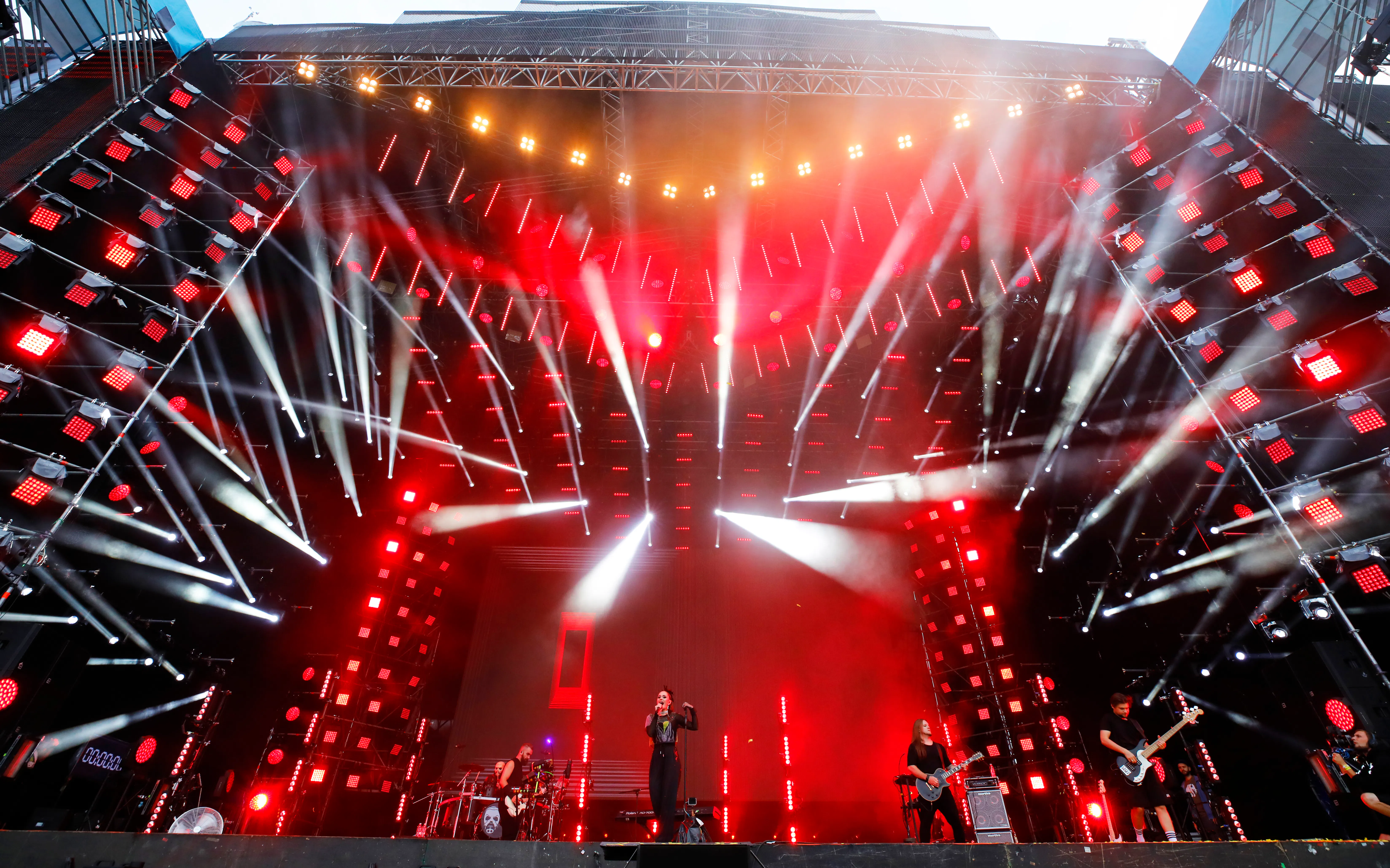 Band performing on the Atlas Weekend stage framed by red LED fixtures and white light beams
