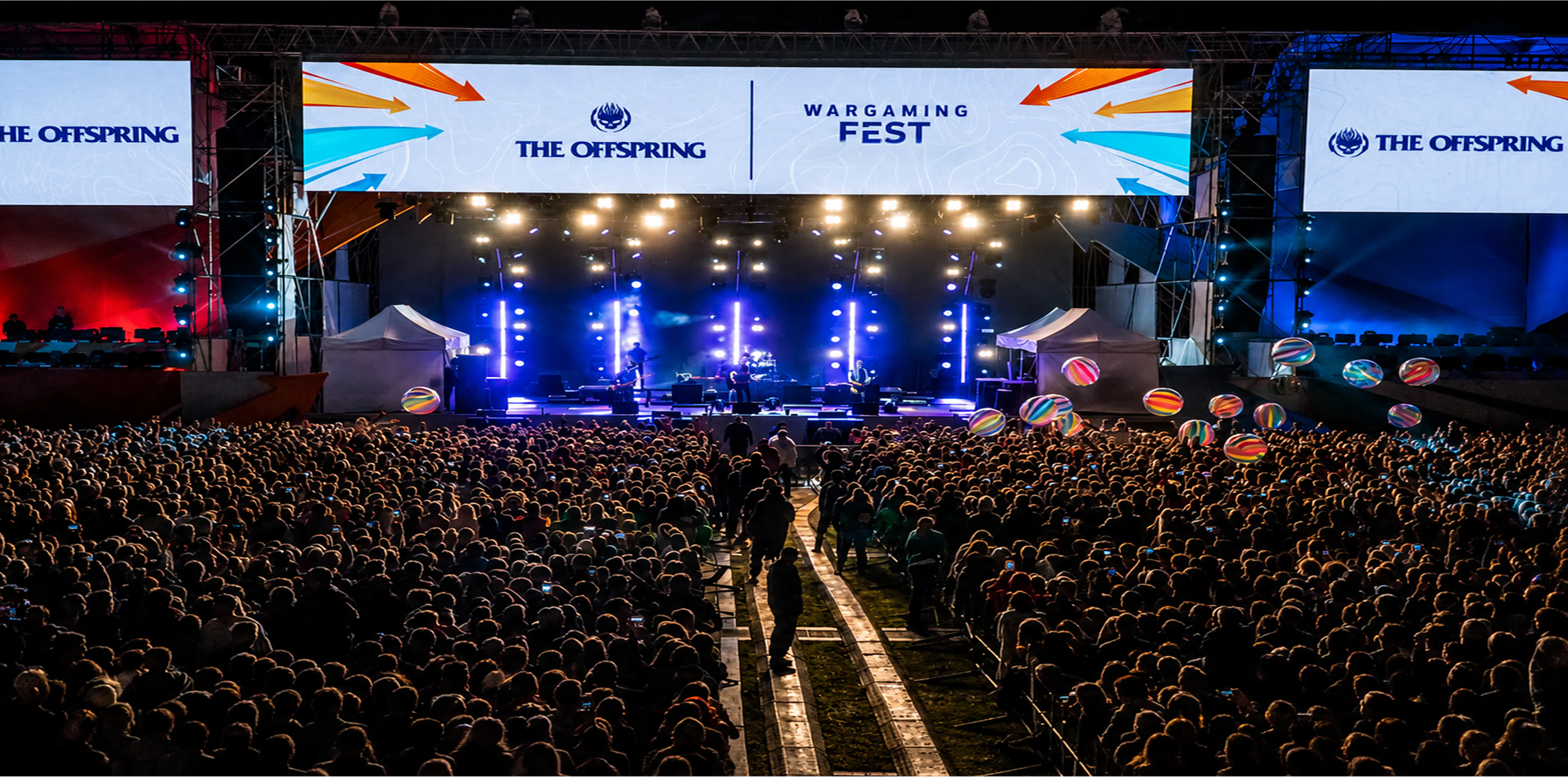 Ogromny tłum przed główną sceną Wargaming Fest z logo The Offspring na ekranach LED i wielkimi dmuchanymi piłkami