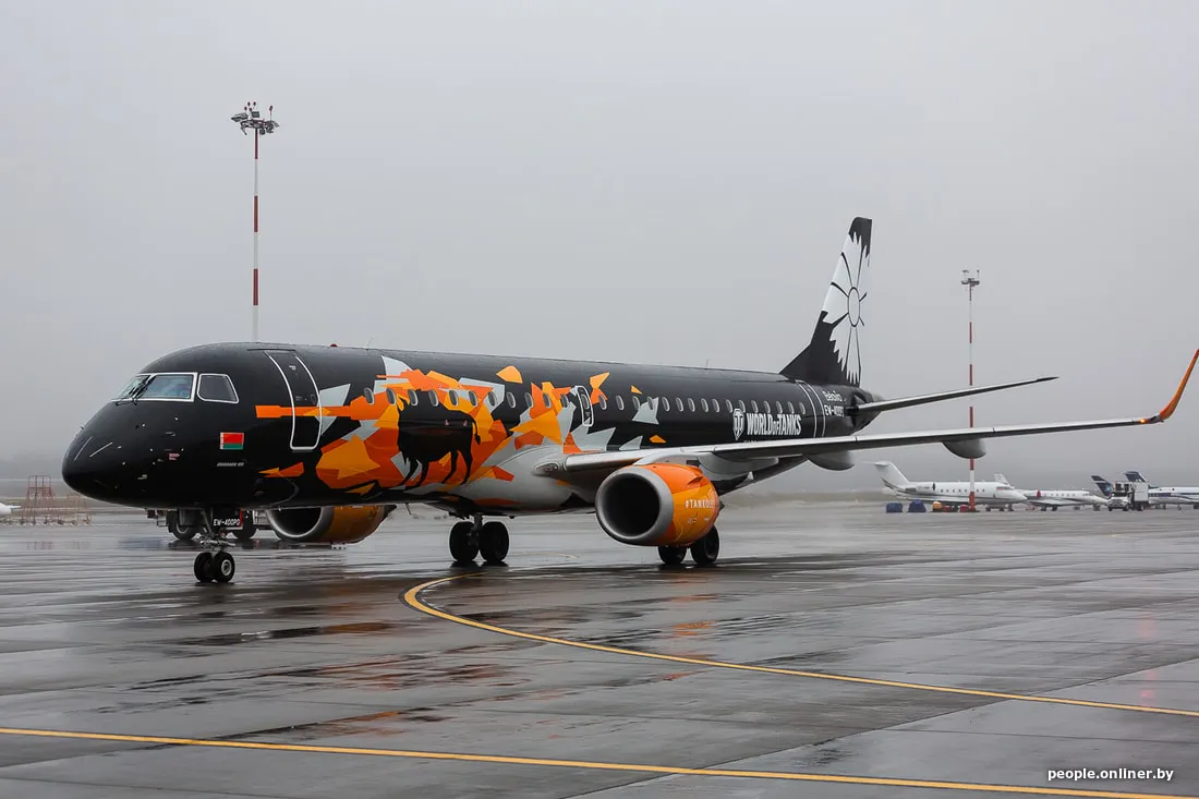 Embraer aircraft with World of Tanks branding and bison livery parked on a rainy airport apron