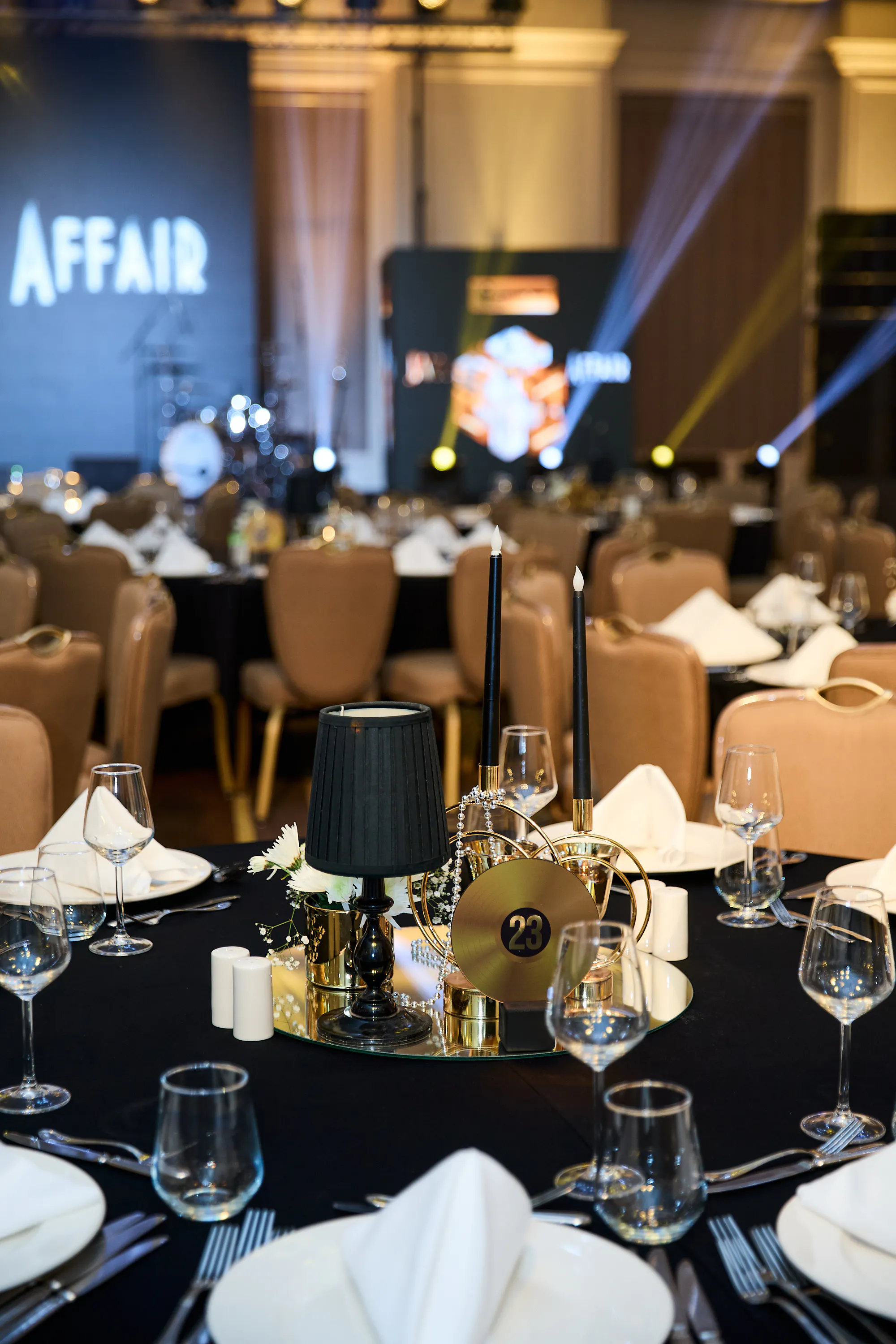 Gala table with black candles, gold decor and table number 23 in front of the Jazz Affair stage